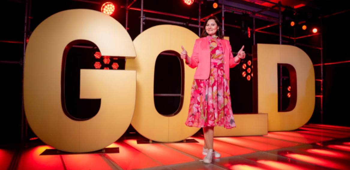 Yulia van Laak vor den goldenen GOLD-Buchstaben